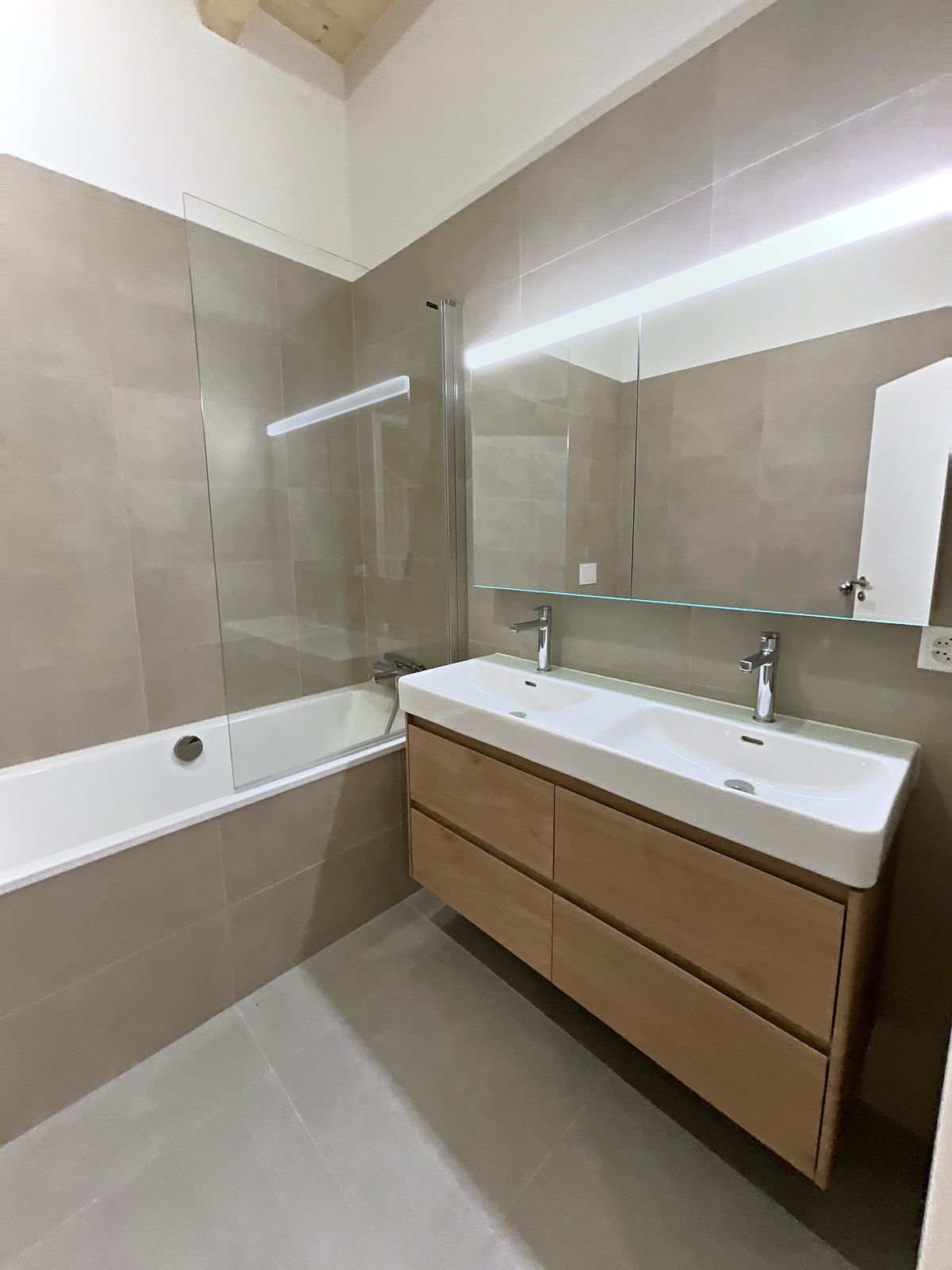 Salle de bain avec double vasque et baignoire